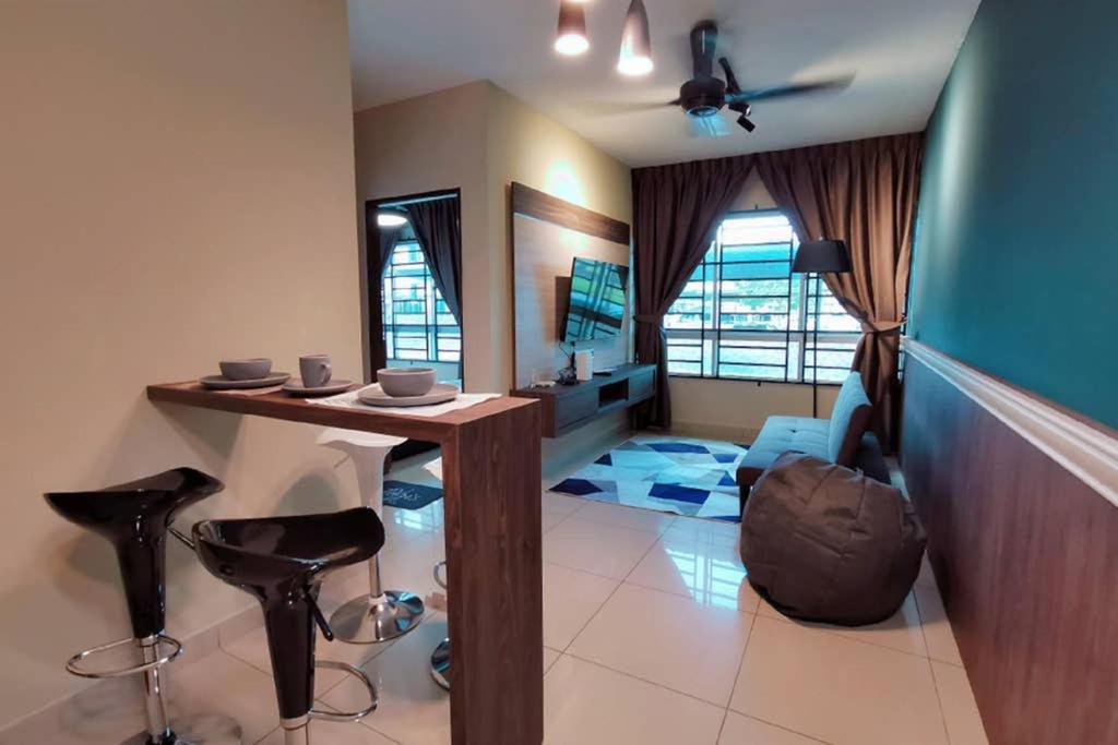 a living room with a table and some stools at Comfort home 5min to Airport 15min to city center 近机场 适合小家庭 安静小区 in Penampang