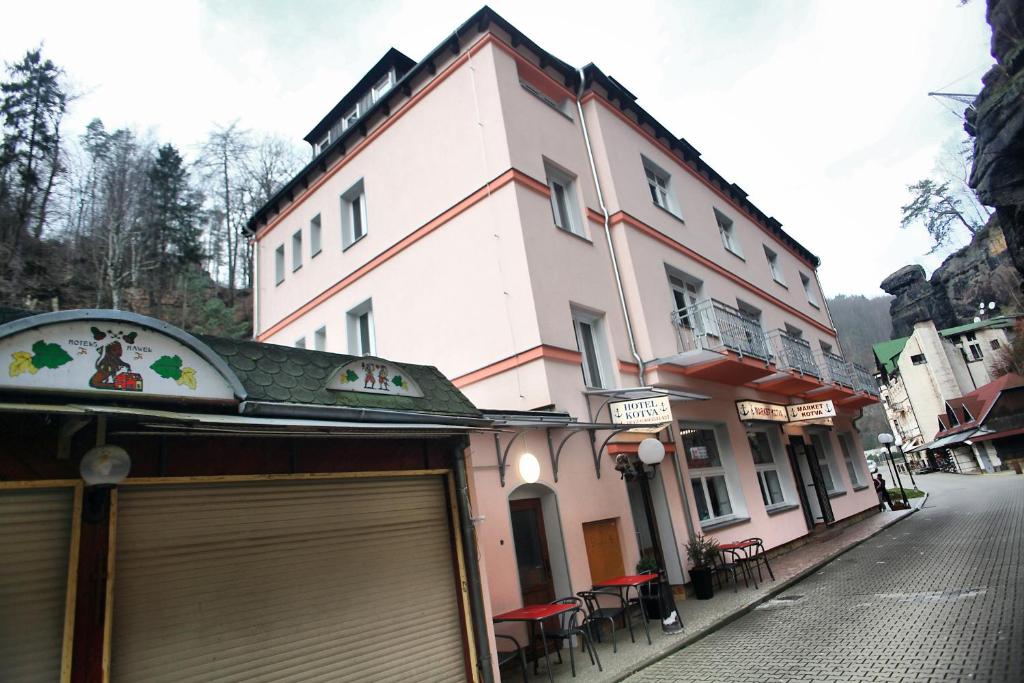a large white building on the side of a street at Hotel Kotva in Hřensko