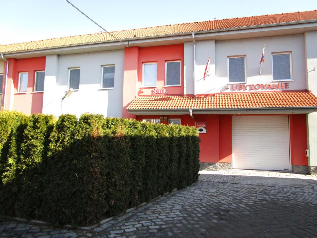 un edificio rojo y blanco con garaje en Salur en Nové Zámky