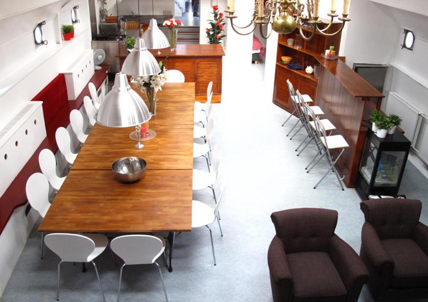 een eetkamer met een houten tafel en stoelen bij Boat Hotel SIX Rotterdam in Rotterdam