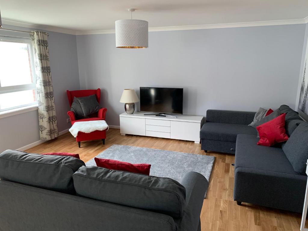 salon z kanapą i telewizorem w obiekcie Flat One, 212 Eaglesham Road, East Kilbride, Glasgow w Glasgow