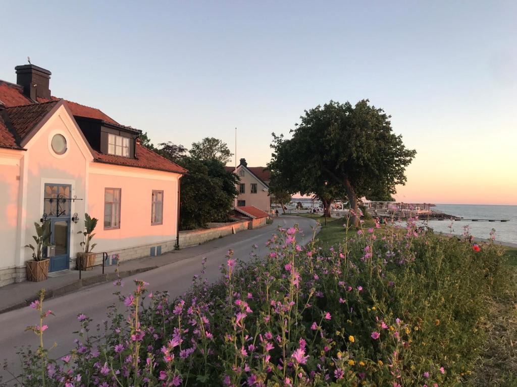 una strada in una città con fiori rosa di Villa Alma a Visby