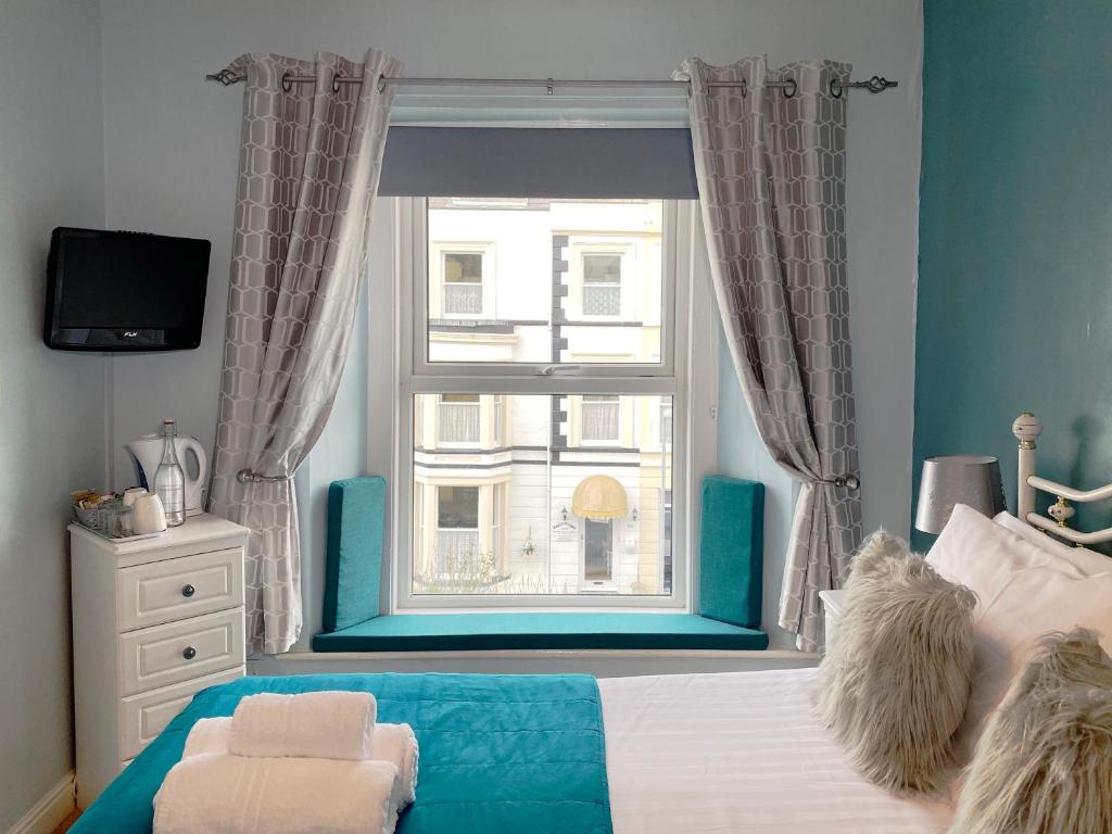 a bedroom with a bed and a window with a view at No 6 Quality Guesthouse in Llandudno