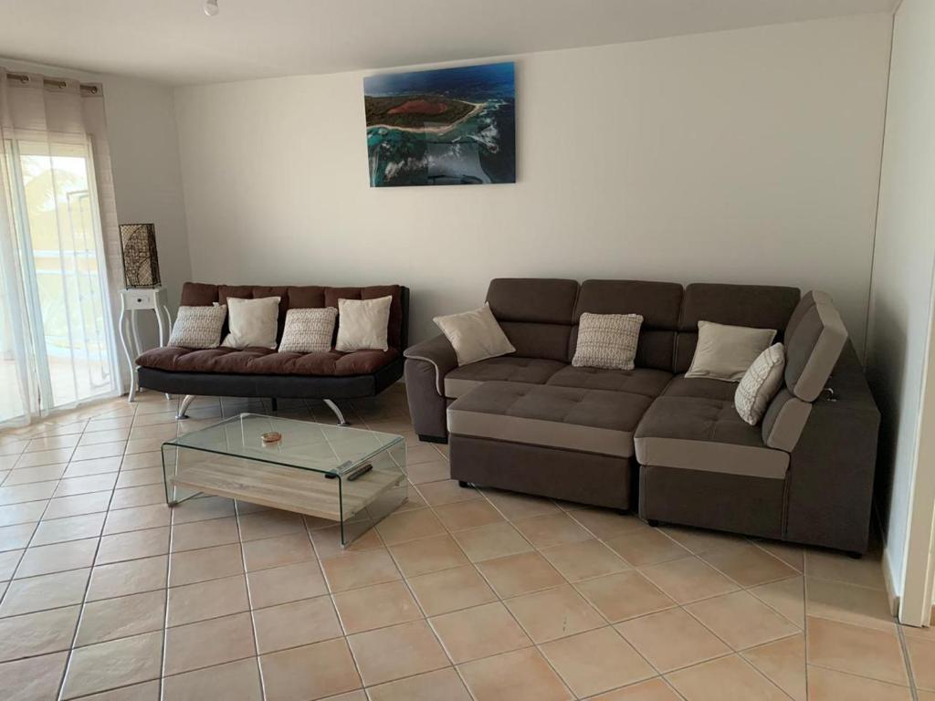 a living room with a couch and a coffee table at logement entier vue sur mer in Gourbeyre