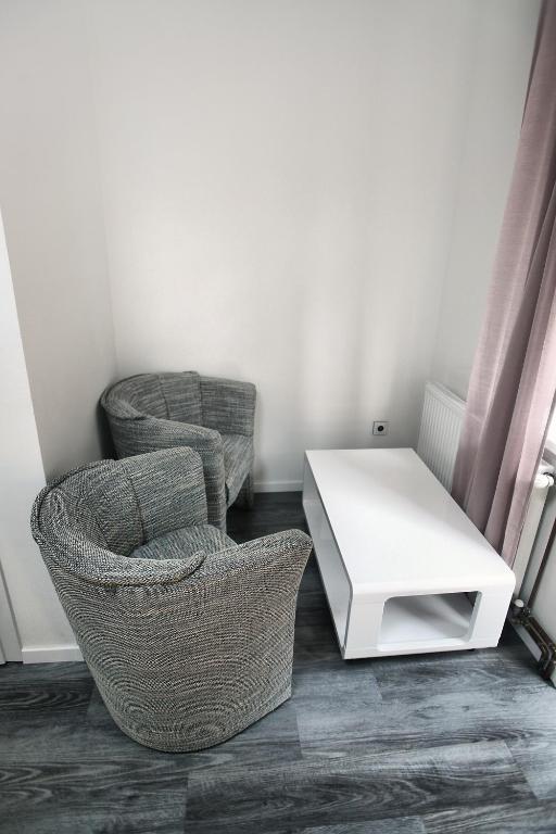 two chairs and a white table in a room at Hotel Kotva in Hřensko