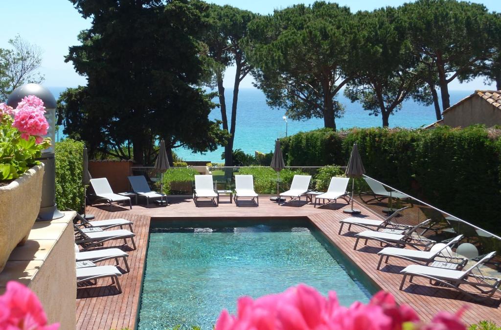 - une piscine avec des chaises longues et un groupe d'écran dans l'établissement Hôtel La Pinède, à Ajaccio
