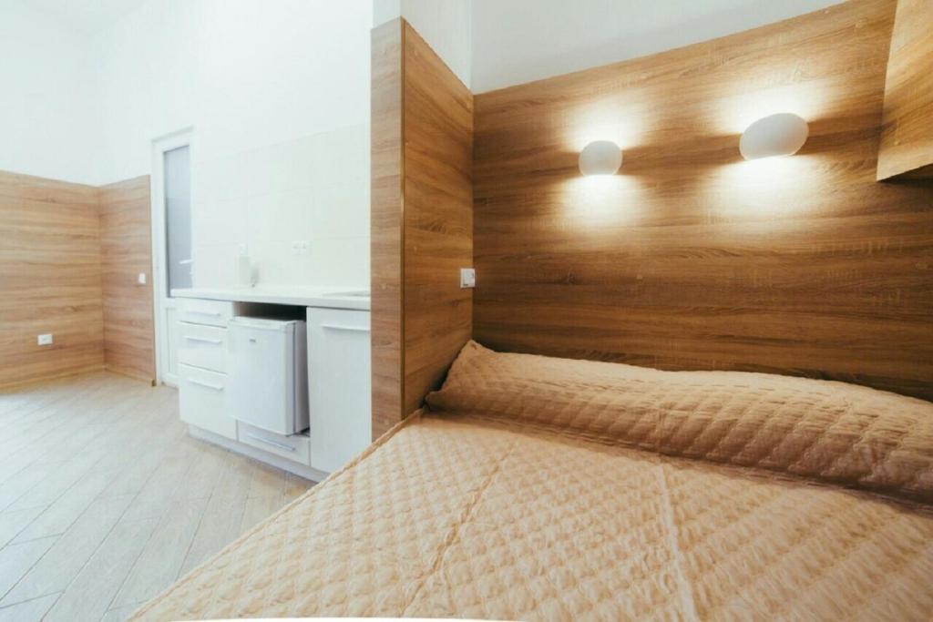 リヴィウにあるApartment on Kulisha 29 -Mini Economy apartments in the central part of Lvivのベッドルーム1室(木製ヘッドボード付きのベッド1台付)