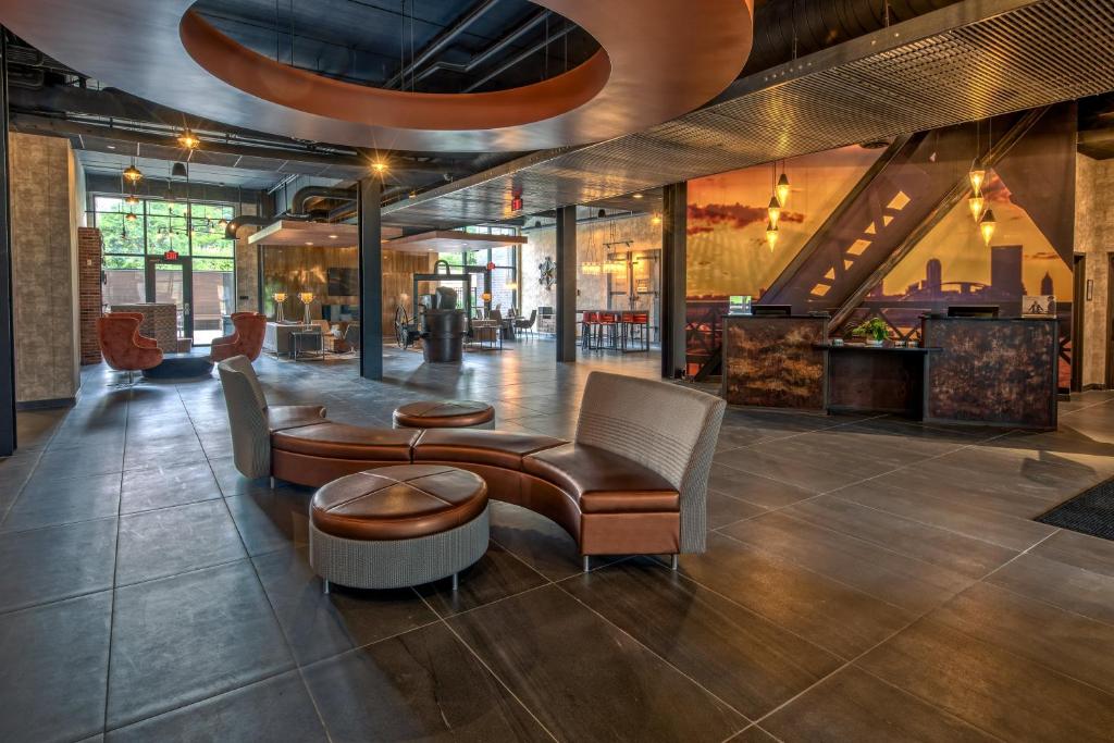 a lobby with a couch and chairs and a table at Hotel Indigo Pittsburgh University - Oakland, an IHG Hotel in Pittsburgh