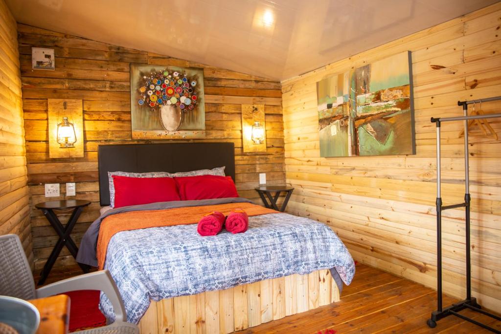 - une chambre avec un lit doté d'oreillers rouges dans l'établissement Blyde Africa- Cottage, à Benoni