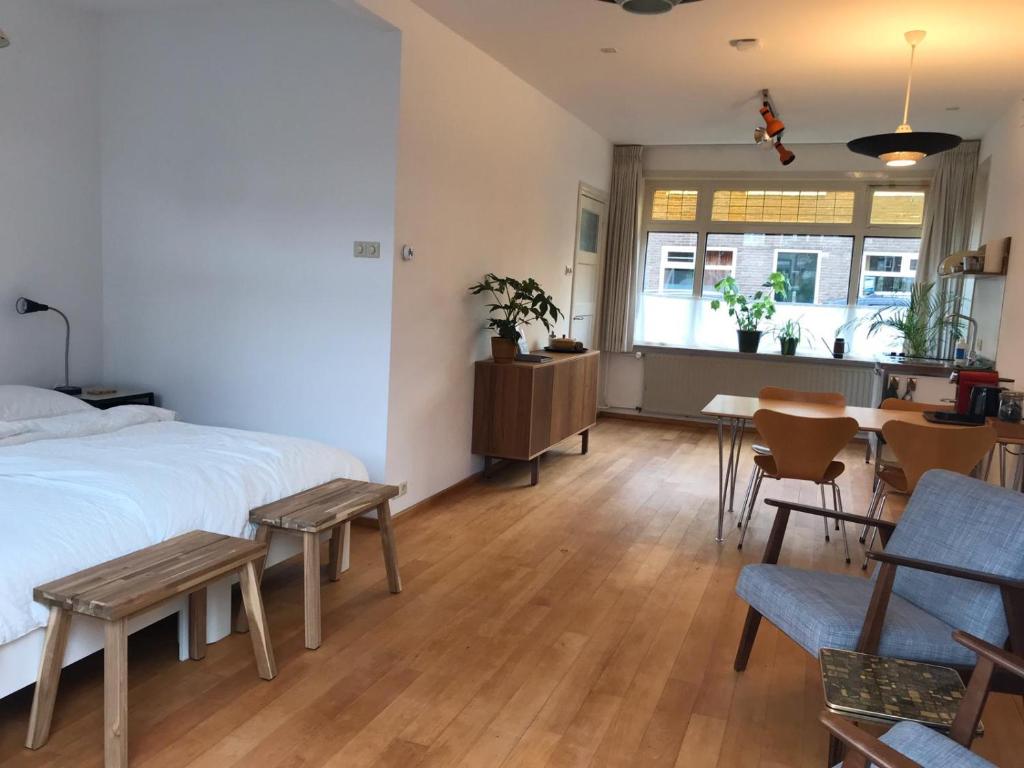 1 dormitorio con 1 cama, mesa y sillas en Huis nummer 1, en Eindhoven