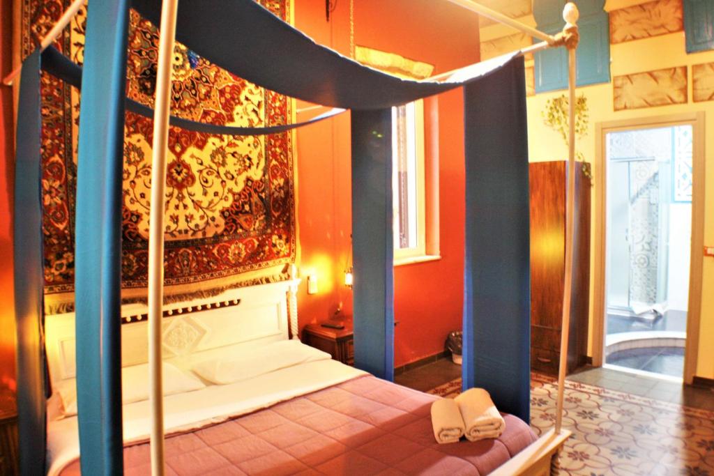 a bedroom with a canopy bed with two shoes on it at Hollywood Inn Palermo in Palermo