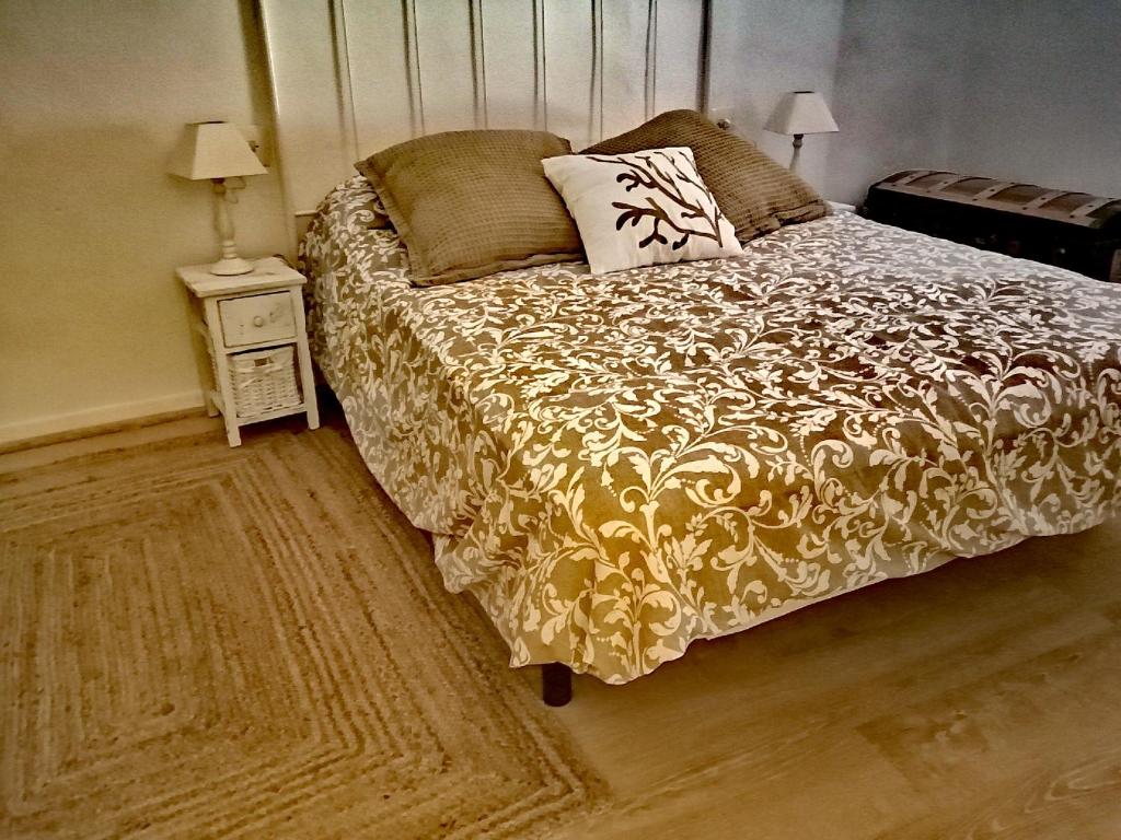 een slaapkamer met een bed en een tafel met een nachtkastje bij Casa tia Juanita in Calaceite