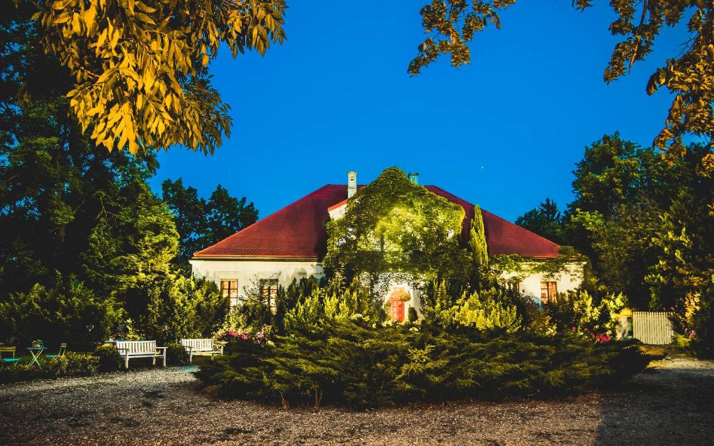 une maison avec un toit rouge et des plantes devant elle dans l'établissement Dwór Giemzów Hotel - Autostrada A1, à Łódź