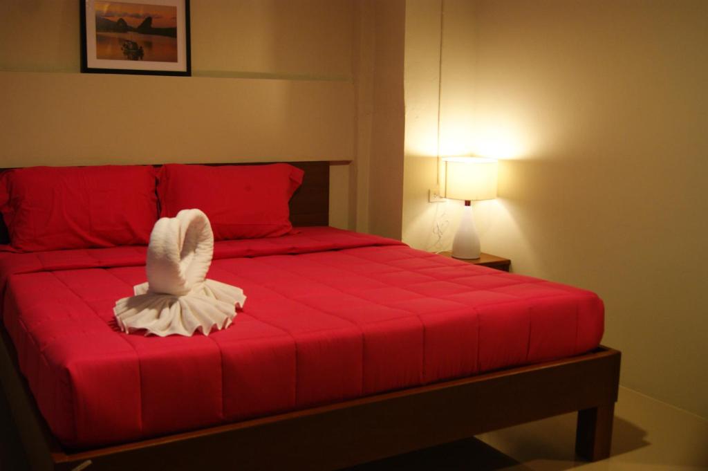 喀比的住宿－城市之家旅館，卧室配有红色的床,上面有一只白色鸟