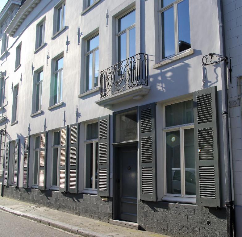 un edificio blanco con ventanas con persianas y una puerta en B&B Huyze Weyne, en Brujas