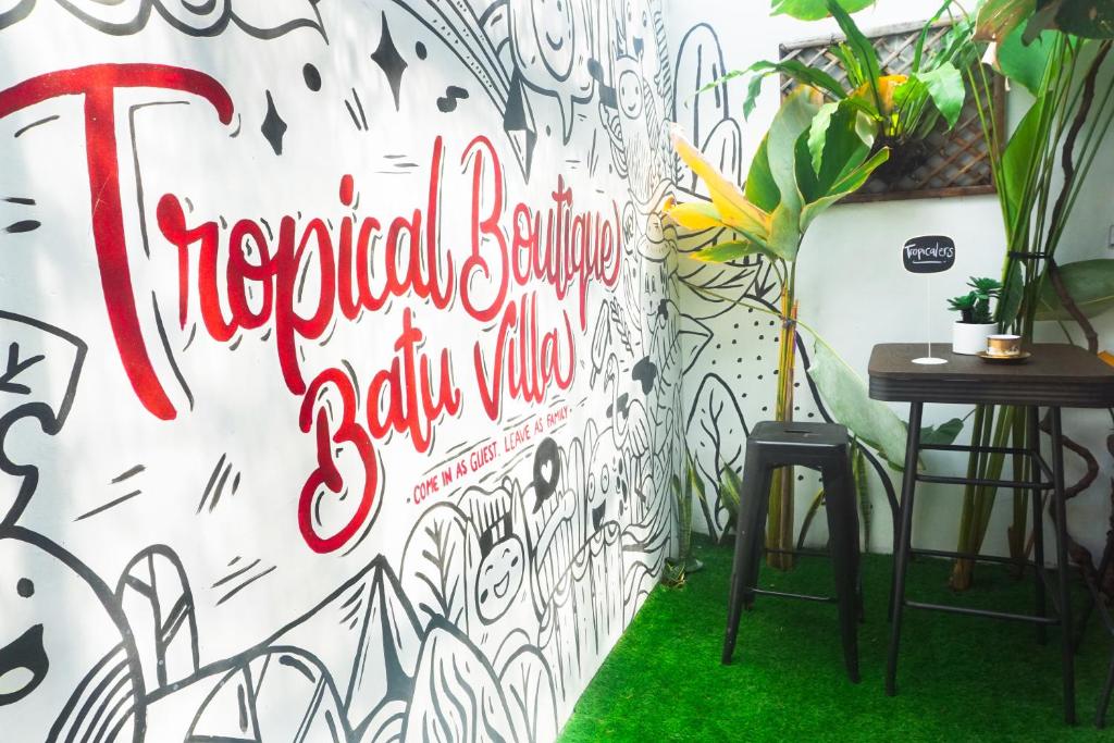 a wall with a sign that reads reopened boutique salivating salivating wine at Tropical Boutique Batu Villa, Near Museum Angkut in Batu