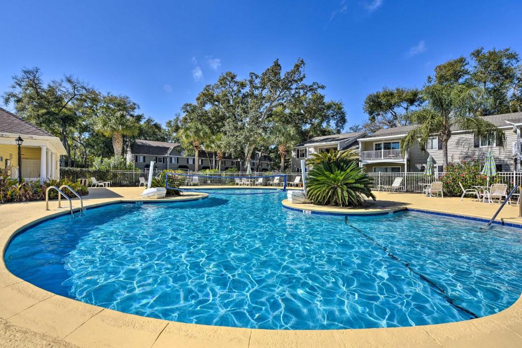 a large swimming pool in a yard with houses at St Simons Condo with Resort Amenities 1 Mi to Beach in Mallory Park