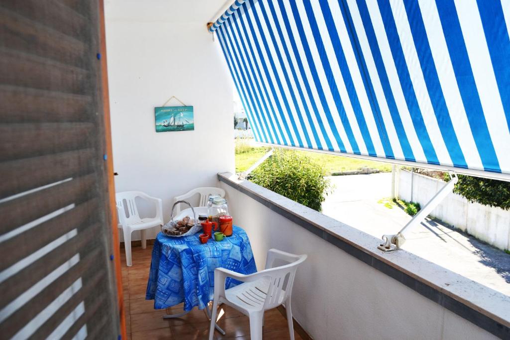 a balcony with a table and chairs and a window at Casa vacanza vicino spiaggia-ll23 in San Foca