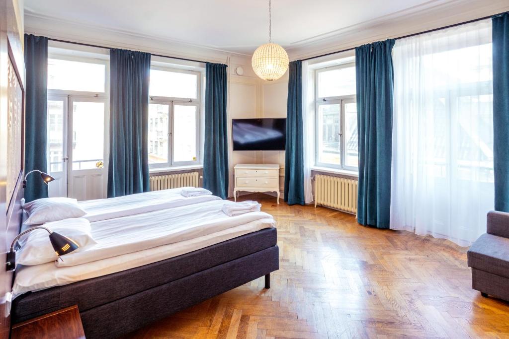 a bedroom with a bed, a desk, and a window at Queen's Hotel in Stockholm