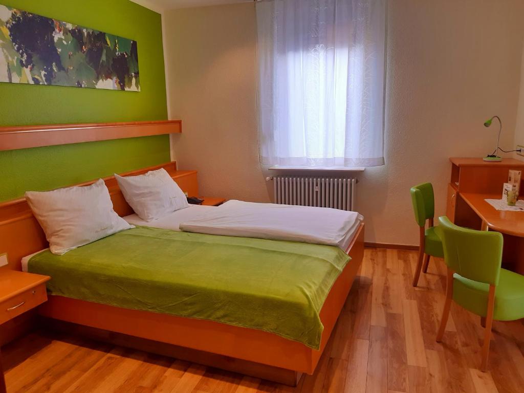 Schlafzimmer mit einem Bett mit grünen Wänden und einem Fenster in der Unterkunft Hotel-Gasthof Zum Freigericht in Alzenau in Unterfranken