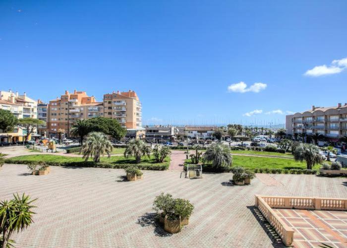 un parco con palme, panchine ed edifici di Hyères Parc- Vue mer Méditterannée a Hyères