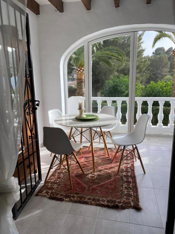 モライラにあるTranquil settingの窓付きの客室で、白いテーブルと椅子が備わります。