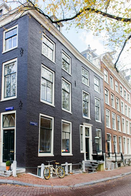 un bâtiment noir avec deux vélos garés devant lui dans l'établissement Mokum Suites, à Amsterdam