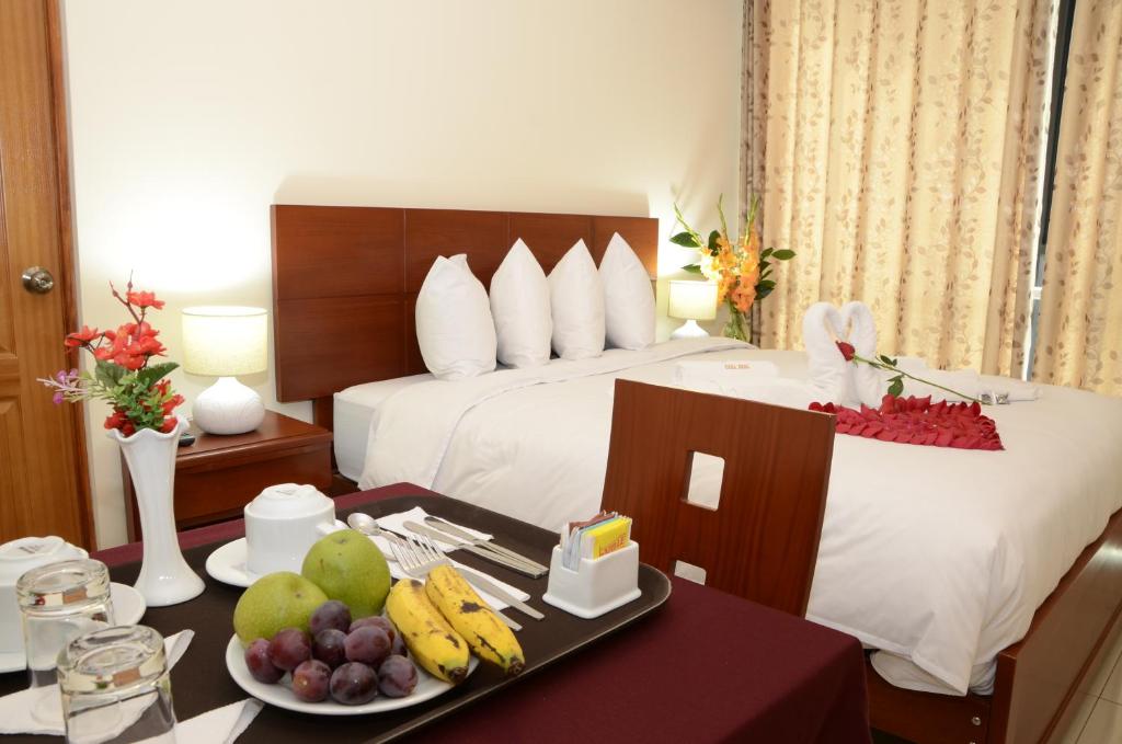 Habitación de hotel con cama y mesa con fruta en Casa Real Hoteles, en Cusco