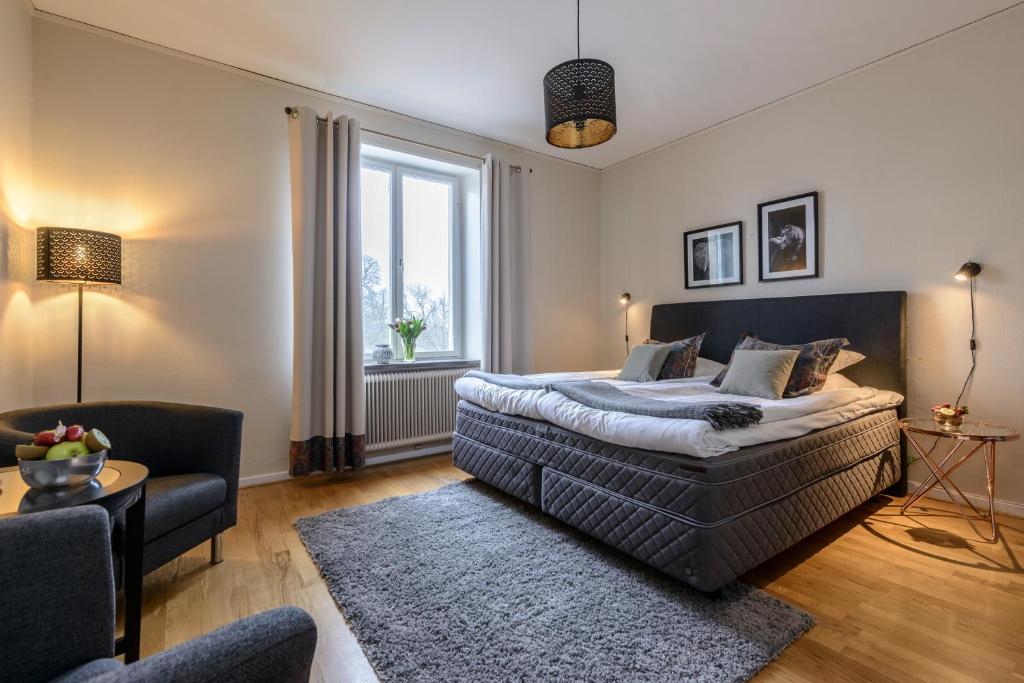 a bedroom with a bed and a living room at Hotel Park Allé in Kristianstad