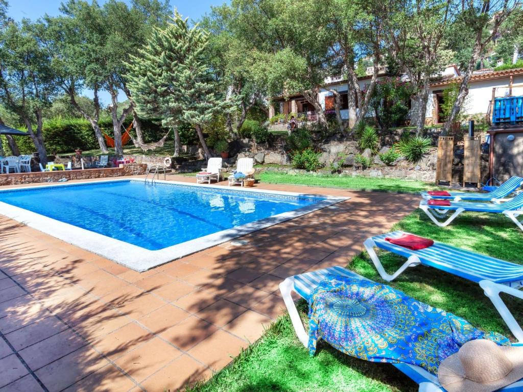 una piscina con 2 sillas de césped y 2 sillas de jardín en Holiday Home La Plaza by Interhome, en Calonge
