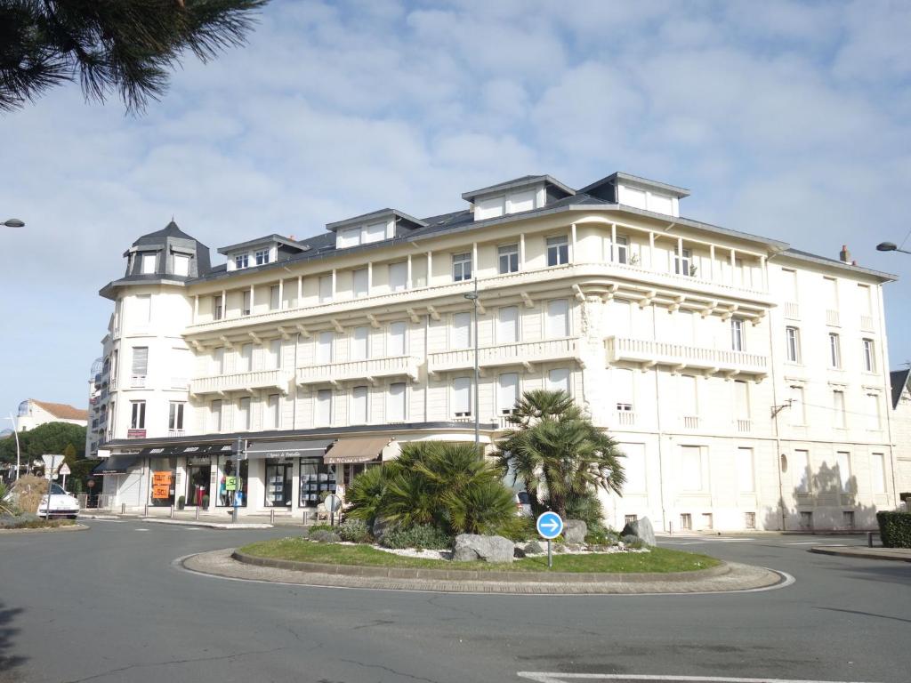 a large white building with palm trees in front of it at Apartment de la Plage et d'Angleterre by Interhome in Royan