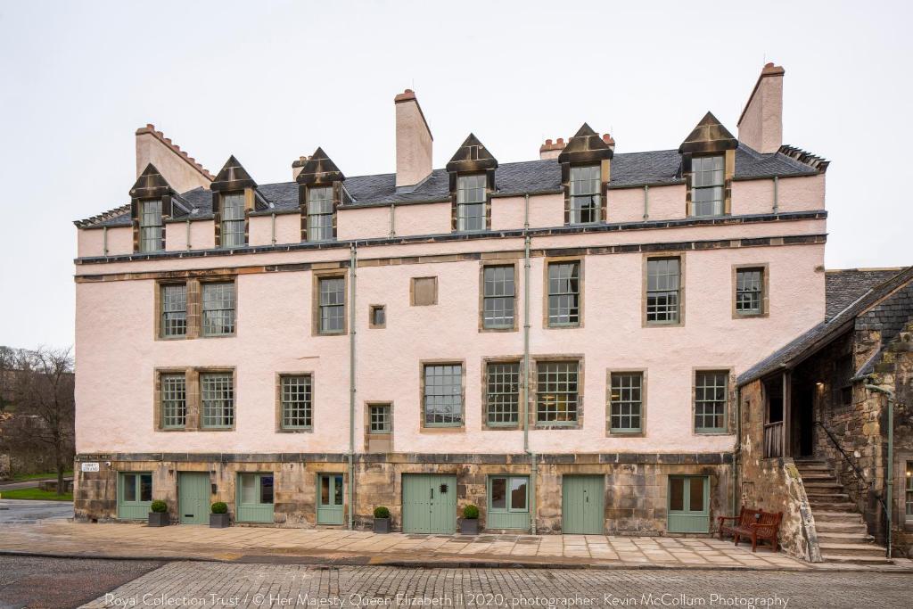 un gran edificio de ladrillo con puertas y ventanas verdes en Cheval Abbey Strand Apartments, at Holyrood, en Edimburgo