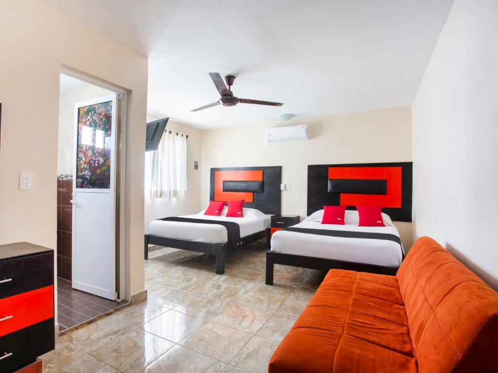 a living room with two beds and a couch at Hotel Jardín Cancún in Cancún