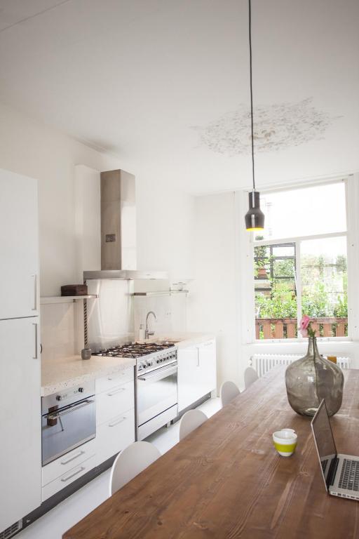 une cuisine avec une table en bois et des appareils électroménagers blancs dans l'établissement Mokum Suites, à Amsterdam