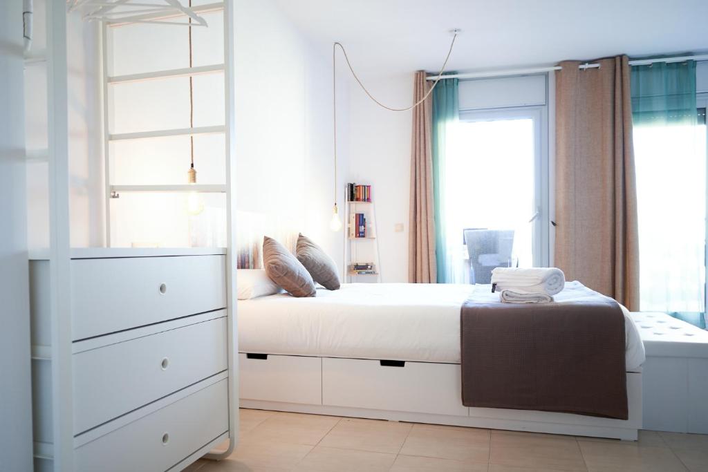a white bedroom with a large bed and a mirror at Mataro Luxury Apartments in Mataró
