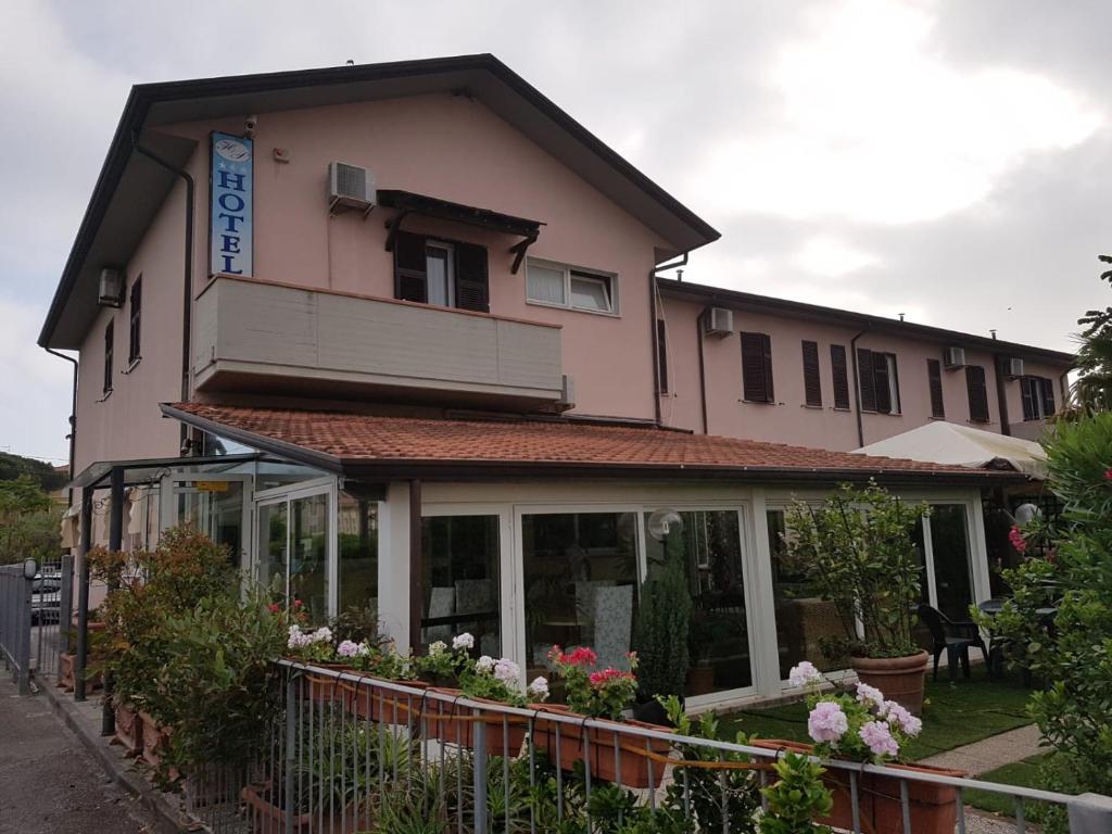 een groot gebouw met bloemen ervoor bij Hotel Patrizia in Marina di Massa