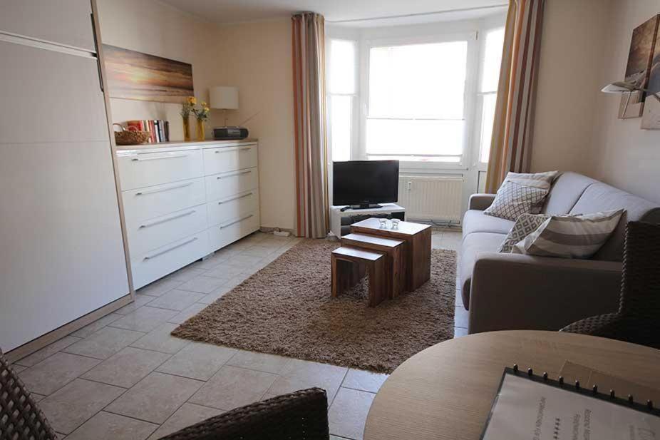 uma sala de estar com um sofá e uma mesa em Ferienwohnung-40-in-der-Residenz-Meeresbrandung-mit-Strandkorb em Cuxhaven