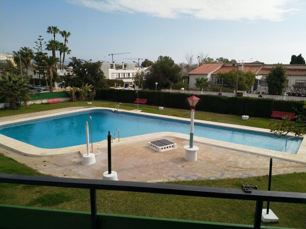 a large swimming pool in a yard next to a building at Casa Sardinero in Torremolinos