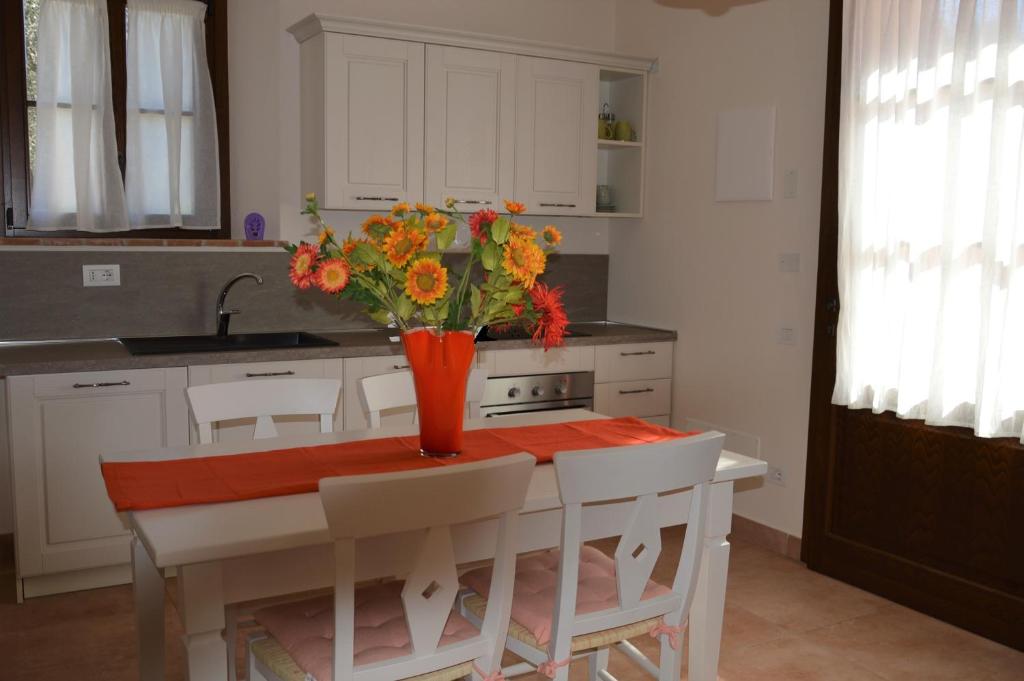 Una cocina con una mesa con un jarrón de flores encima. en Mignola Le Bozze- Podere con piscina-WI-FI, en Castagneto Carducci
