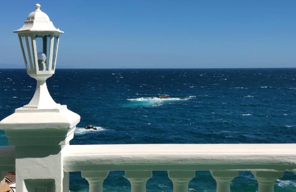 a street light on a balcony looking at the ocean at Sedmoye Nebo Hotel in Utes