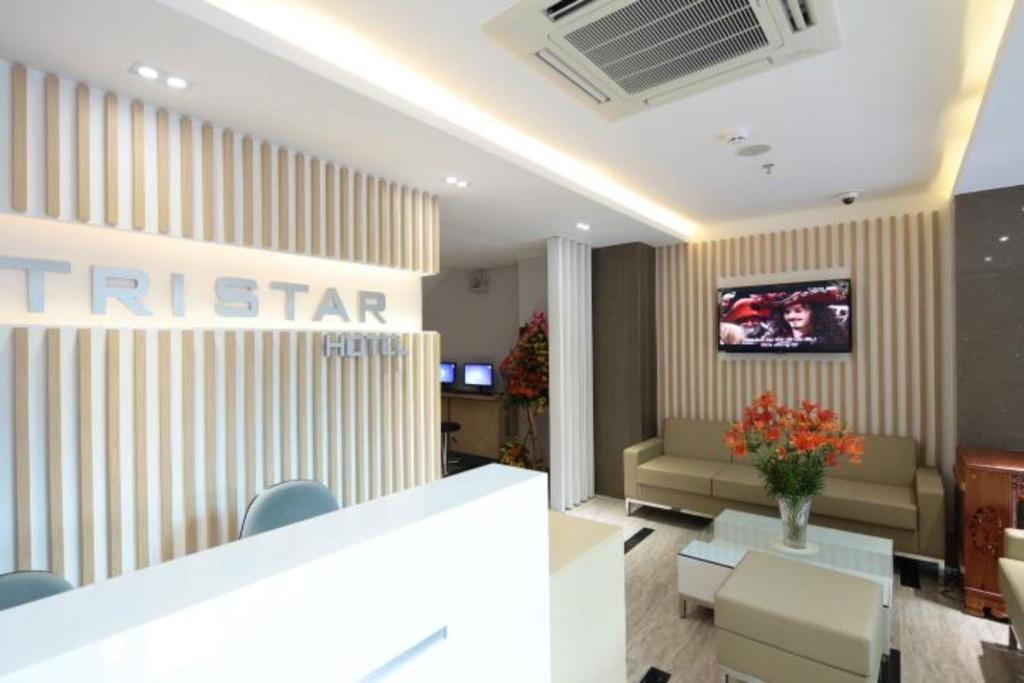 hol hotelowy z kanapą i telewizorem na ścianie w obiekcie Tristar Hotel w mieście Nha Trang