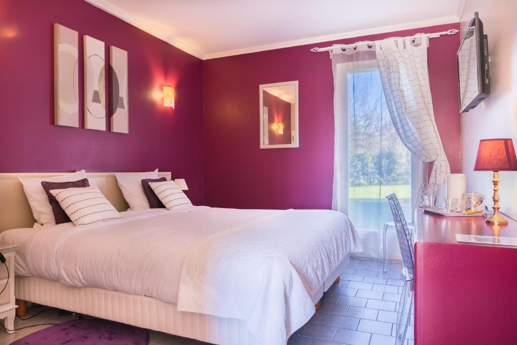 een paarse slaapkamer met een groot bed en een raam bij Logis Hotel Le Nuage in La Bussière