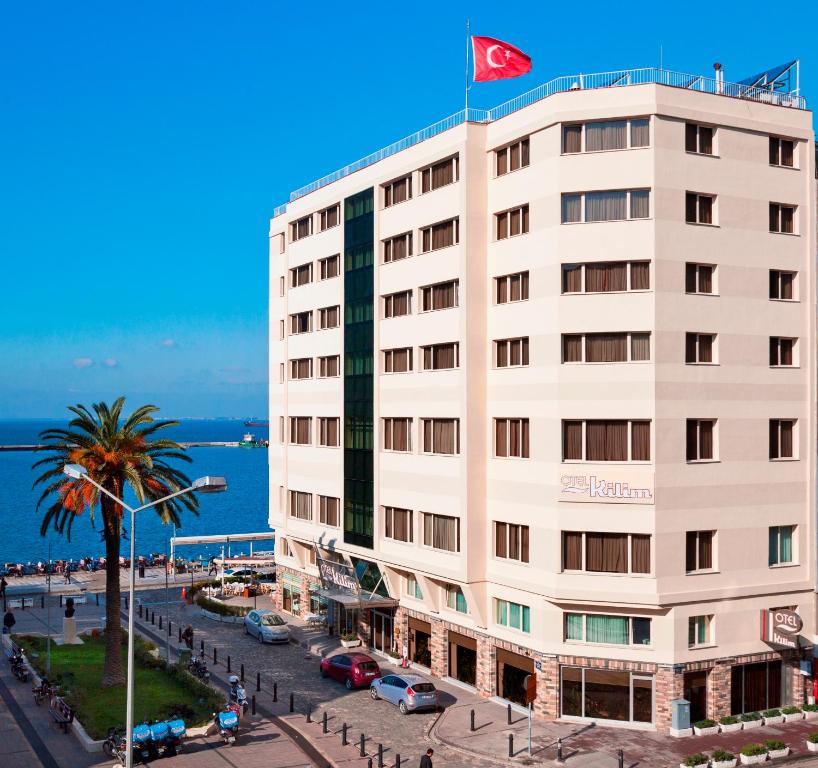 a white building with a flag on top of it at Kilim Hotel Izmir in İzmir