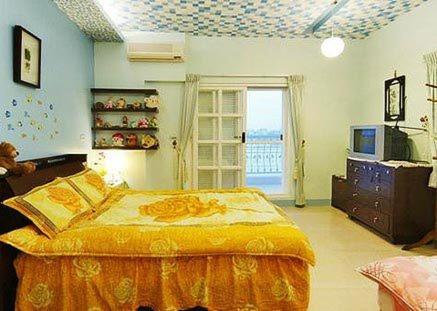 - une chambre avec un grand lit et une télévision dans l'établissement Harmony Village, à Wujie