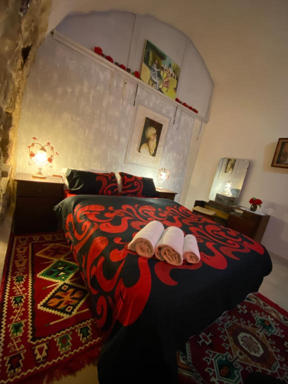 a bedroom with a bed with two slippers on it at Guest House Antique in Nazareth