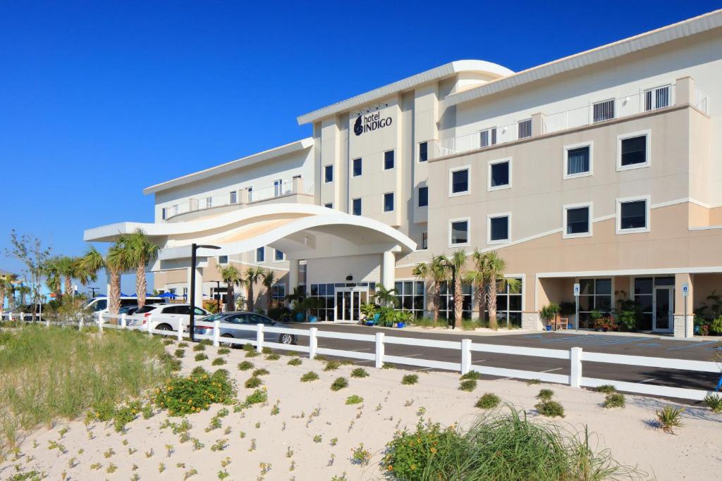 
a large white building with a white fence at Hotel Indigo Orange Beach - Gulf Shores, an IHG Hotel in Gulf Shores
