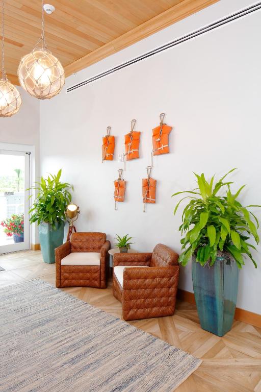 a living room with a couch and chairs and plants at Hotel Indigo Orange Beach - Gulf Shores by IHG in Gulf Shores