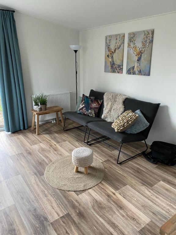een woonkamer met een bank en een tafel bij Welcome in - Vakantiepark Fort den Haak in Vrouwenpolder