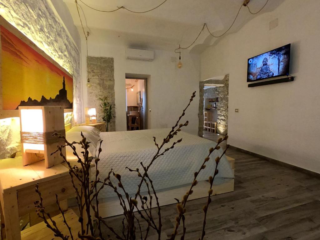 um quarto com uma cama e uma televisão na parede em B&B François le cordonnier maison de charme em Santa Teresa Gallura