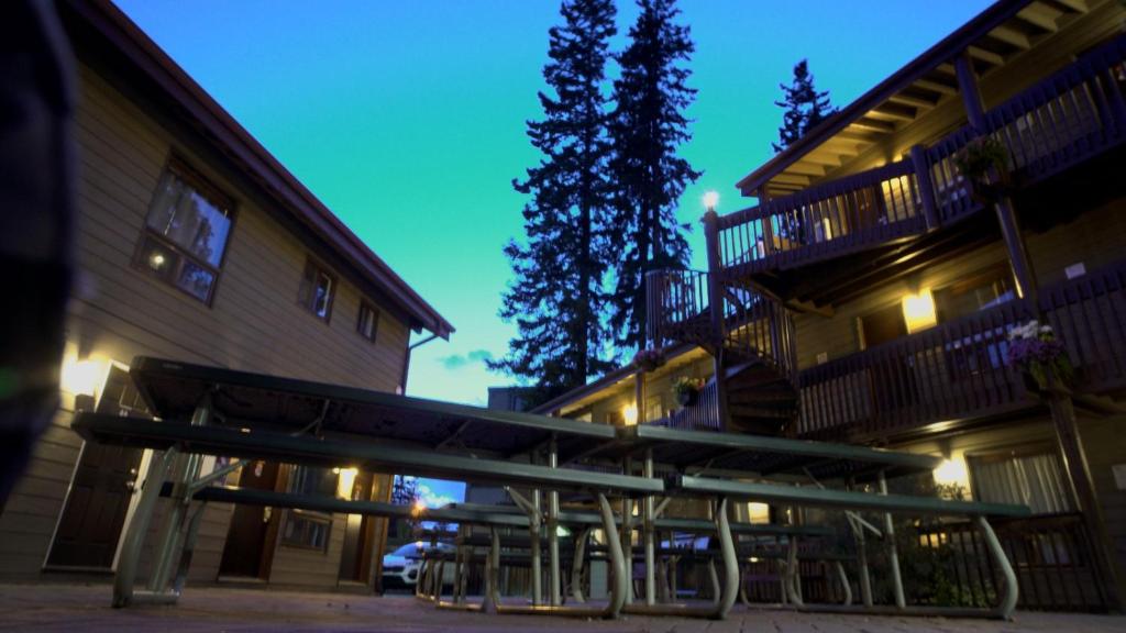 a bench in front of a building at night at Banff International Hostel in Banff